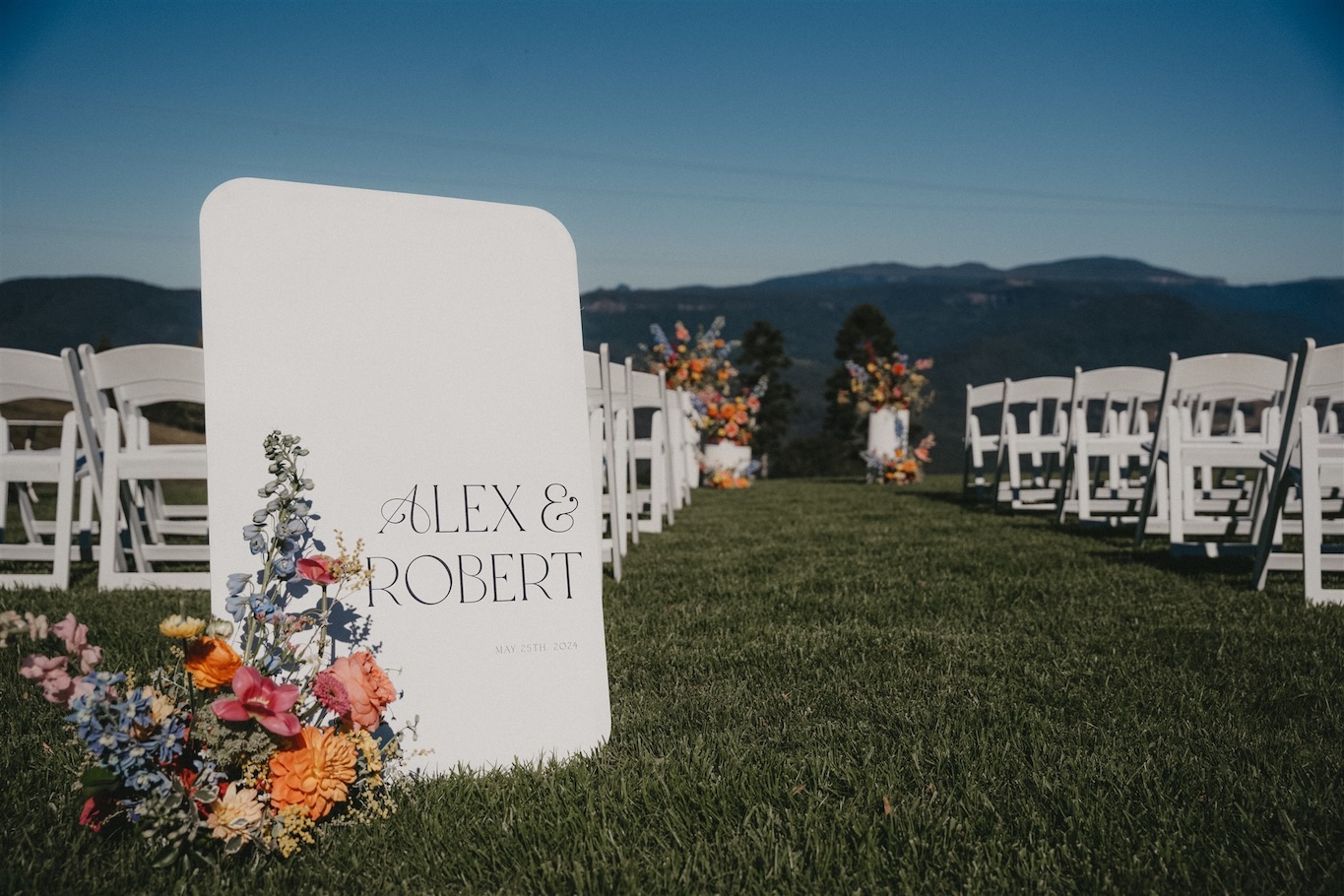 Vibrant floral displays by New England Flower Co with welcome sign thanks to Signed with Love.